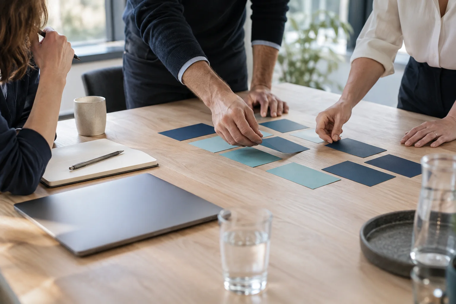 Illustrative scene: people arranging navy and turquoise cards together on a workshop table.